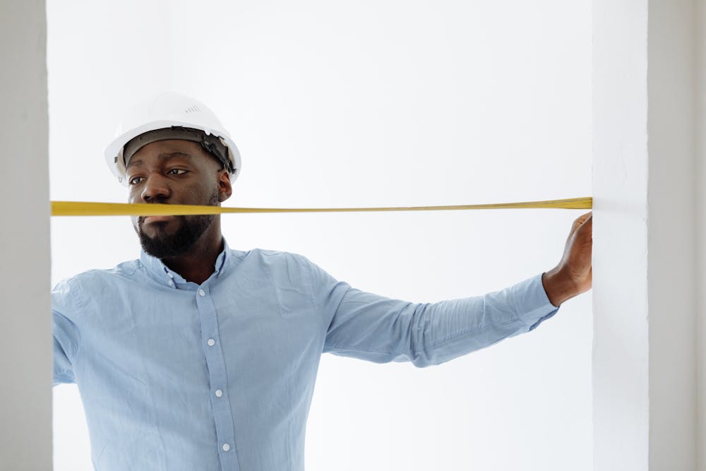 Contractor with tape measure inspecting a project on site